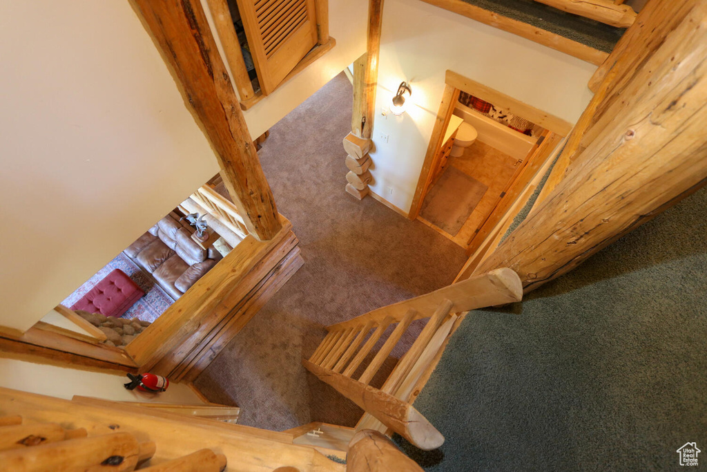 Staircase featuring beamed ceiling and carpet floors