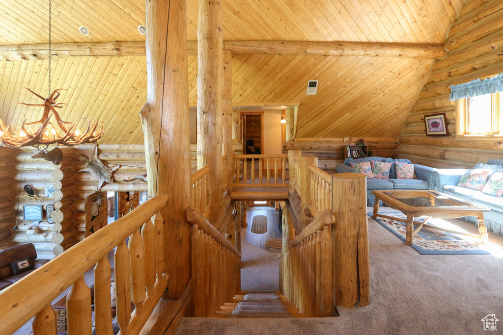 Stairway featuring high vaulted ceiling, log walls, wood ceiling, carpet, and a chandelier