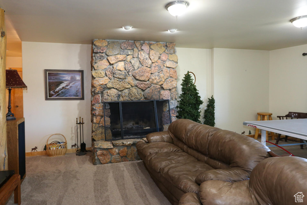 Living room featuring a stone fireplace and carpet