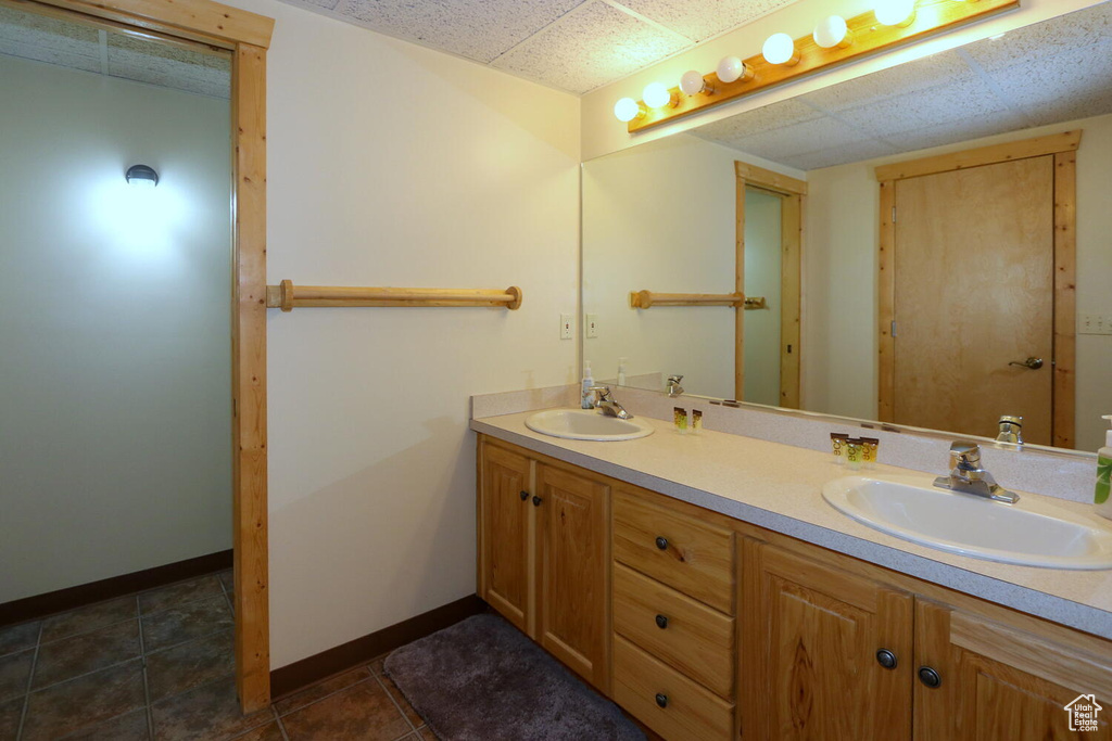 Bathroom with a drop ceiling, tile flooring, and double sink vanity