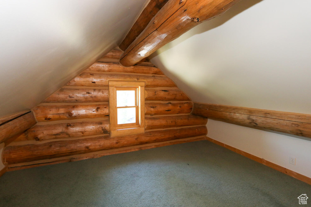 Bonus room featuring rustic walls, carpet floors, and lofted ceiling
