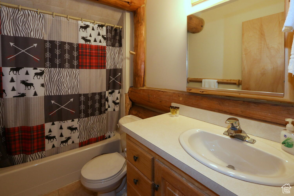 Full bathroom featuring toilet, vanity, and shower / tub combo with curtain