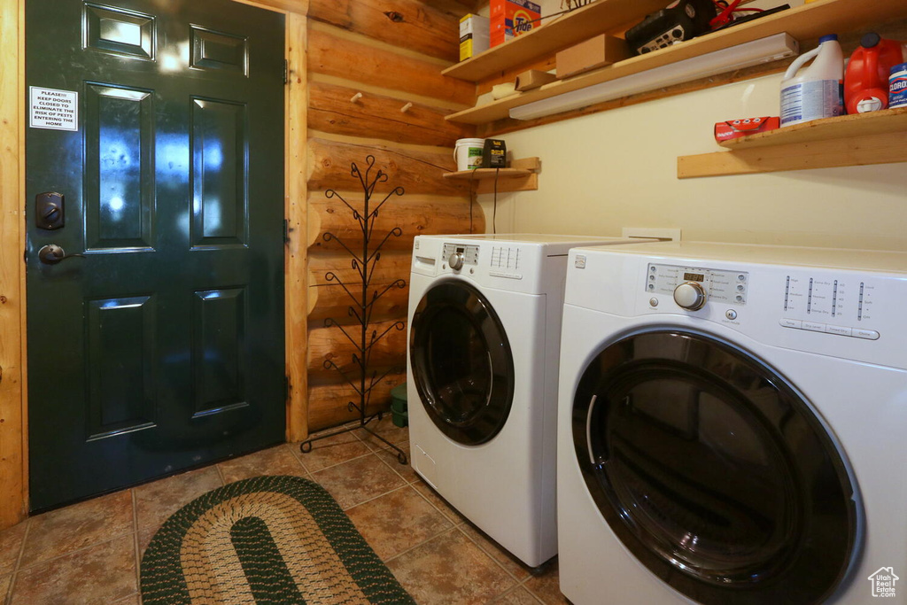 Clothes washing area with washer and clothes dryer and tile flooring