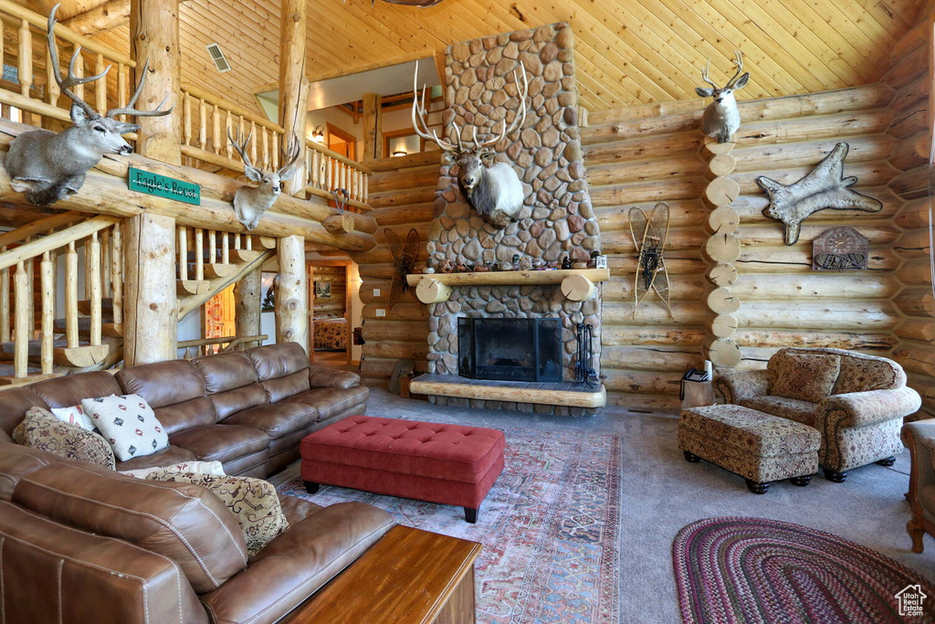 Carpeted living room with a high ceiling, rustic walls, and wood ceiling
