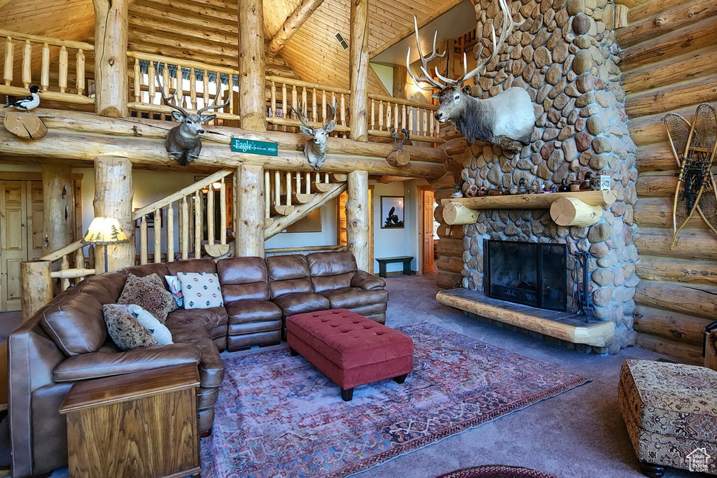 Carpeted living room featuring beamed ceiling, log walls, a stone fireplace, high vaulted ceiling, and wood ceiling