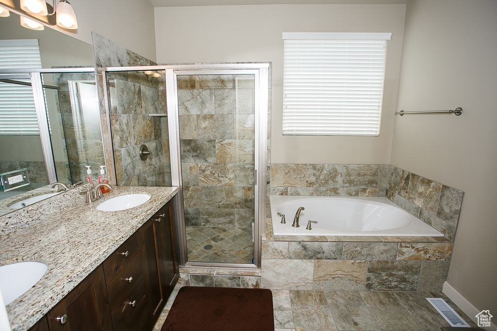Bathroom featuring tile flooring, large vanity, double sink, and separate shower and tub