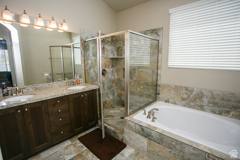 Bathroom featuring double vanity, tile floors, and independent shower and bath