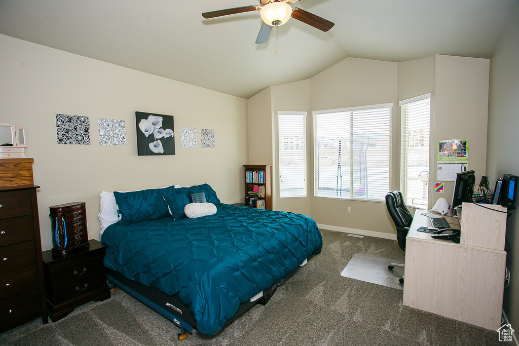 Bedroom featuring ceiling fan, dark carpet, and lofted ceiling