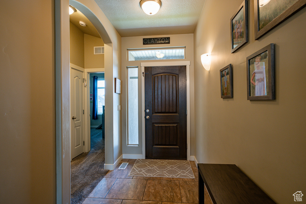 Tiled foyer entrance with a textured ceiling