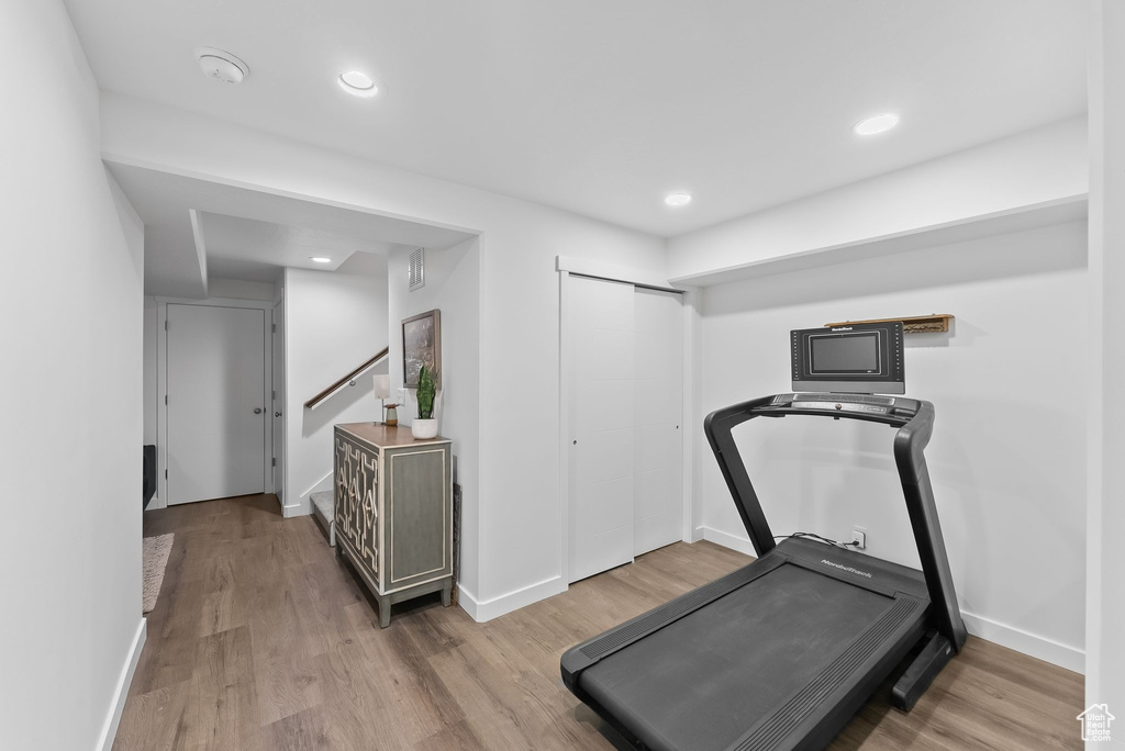 Workout room with light hardwood / wood-style flooring