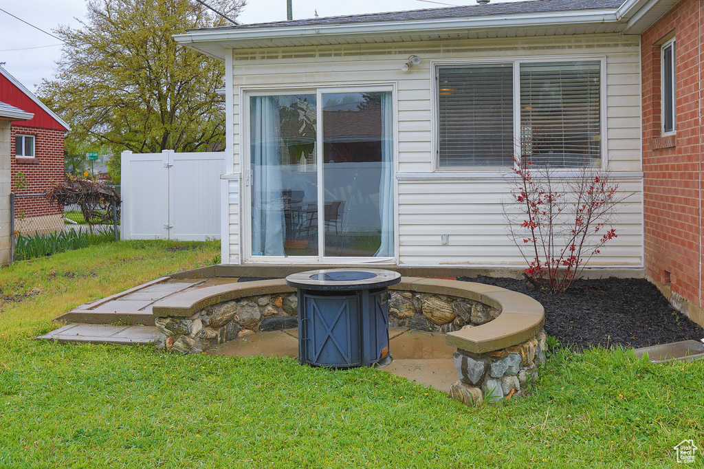 Rear view of house featuring a fire pit and a yard
