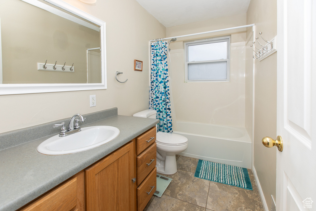 Full bathroom with shower / bath combination with curtain, tile flooring, vanity, and toilet