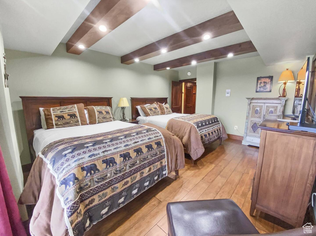 Bedroom featuring hardwood / wood-style floors and beam ceiling