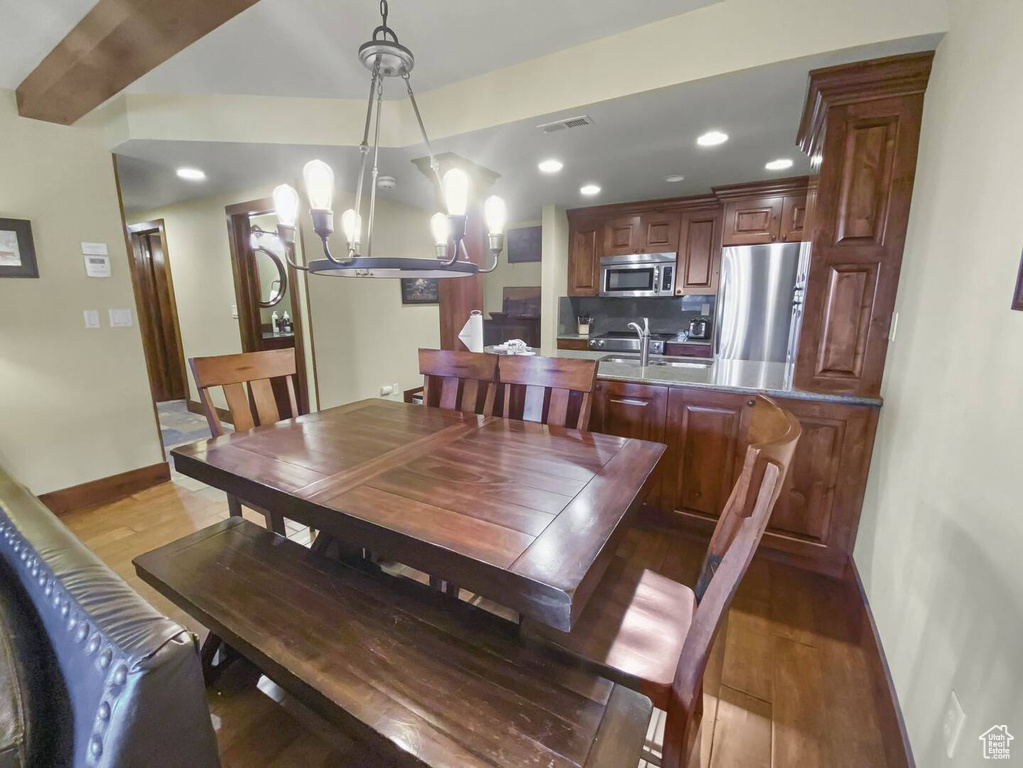 Dining space with light hardwood / wood-style flooring and a notable chandelier