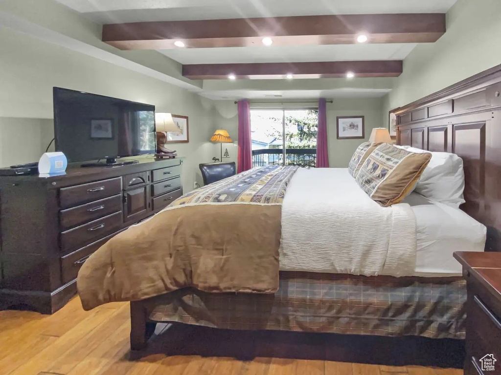 Bedroom with beamed ceiling and hardwood / wood-style flooring
