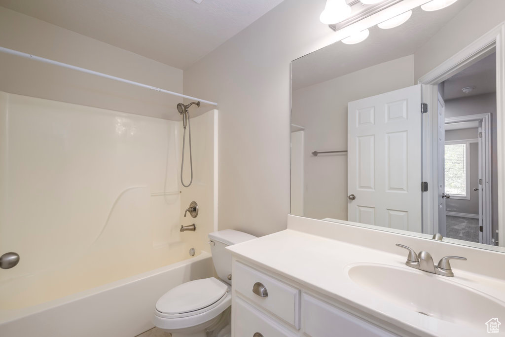 Full bathroom featuring large vanity, shower / bathtub combination, and toilet