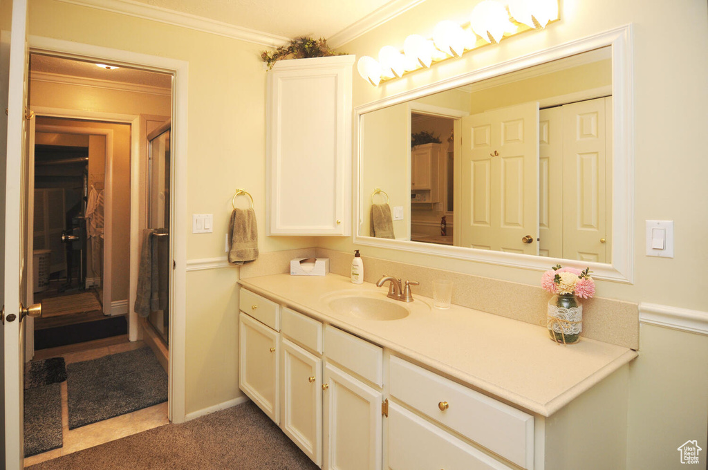 Bathroom with ornamental molding, vanity, and tile floors