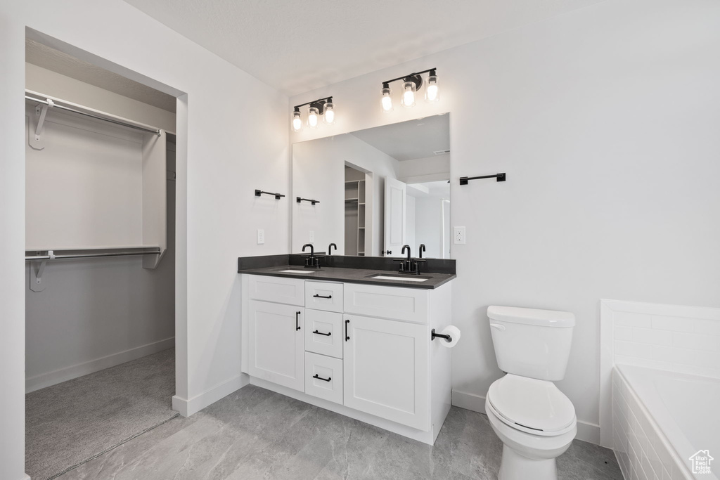 Bathroom with vanity, a bathtub, and toilet