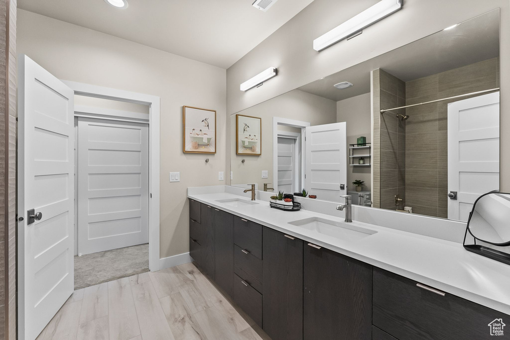 Bathroom with oversized vanity, hardwood / wood-style flooring, and double sink