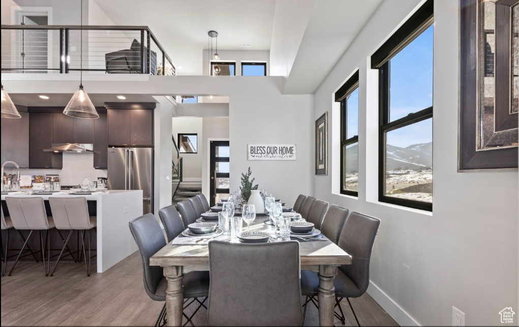 Dining area featuring a mountain view, wood-type flooring, a towering ceiling, and sink