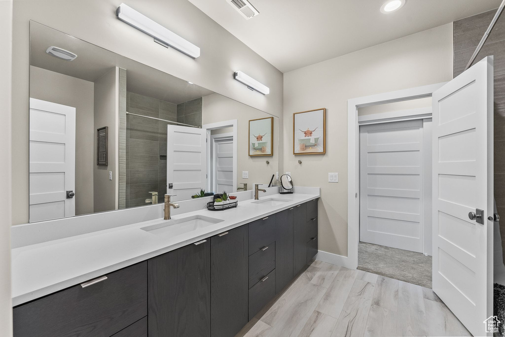 Bathroom with hardwood / wood-style flooring and dual bowl vanity