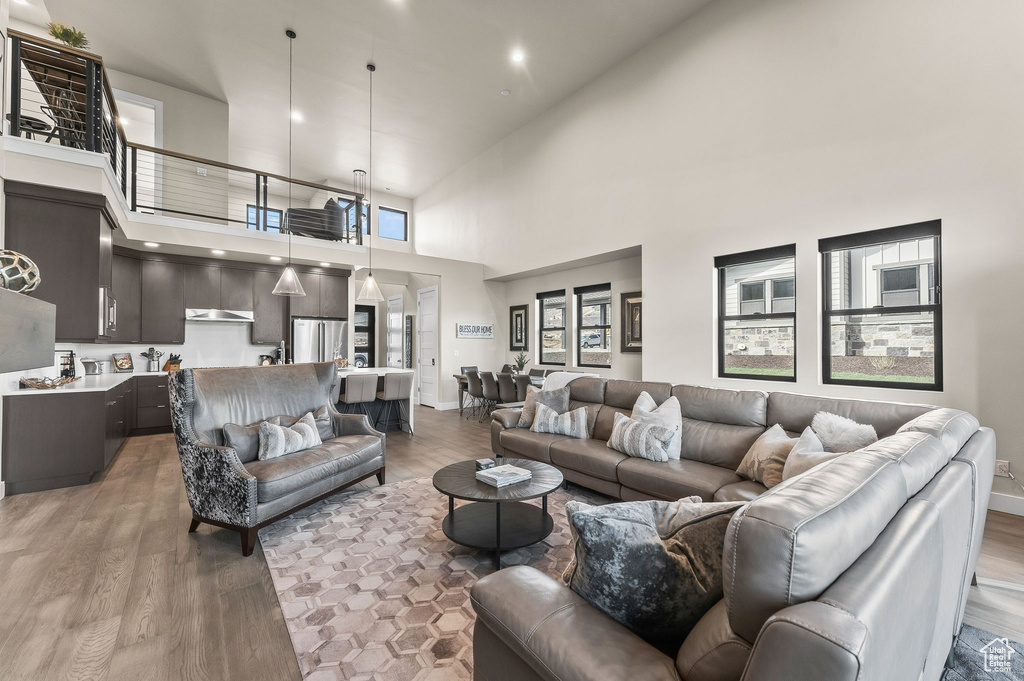 Living room featuring high vaulted ceiling, wood-type flooring, and a wealth of natural light