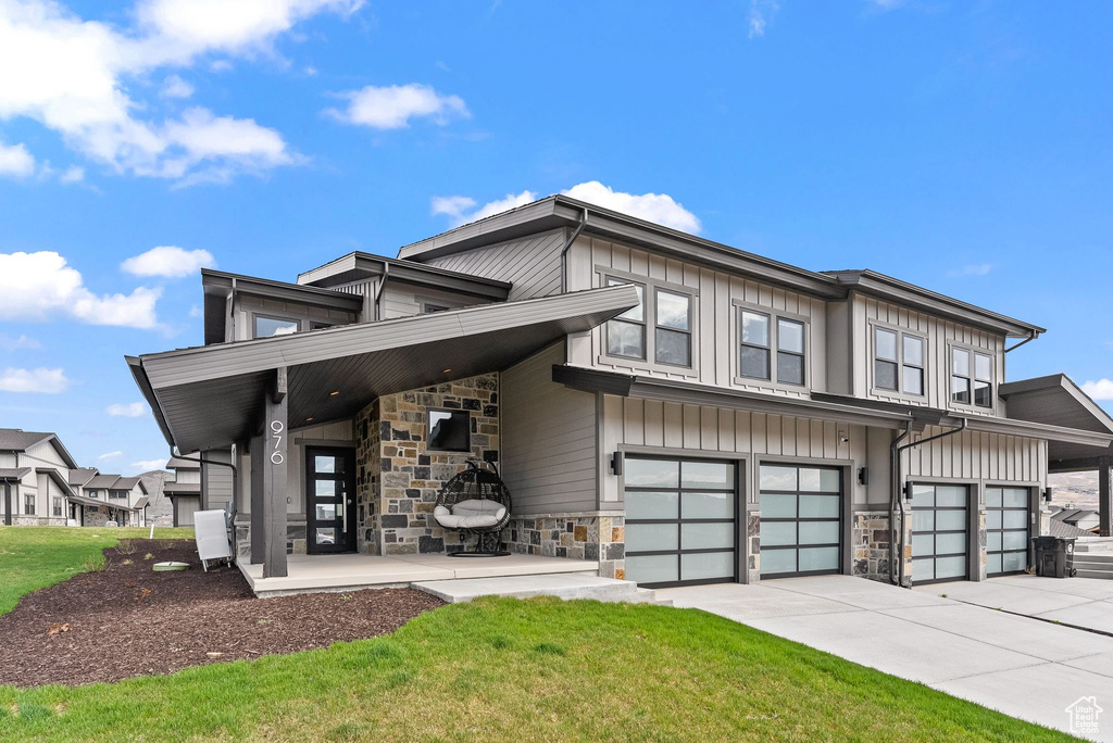 Contemporary house featuring a garage and a front lawn