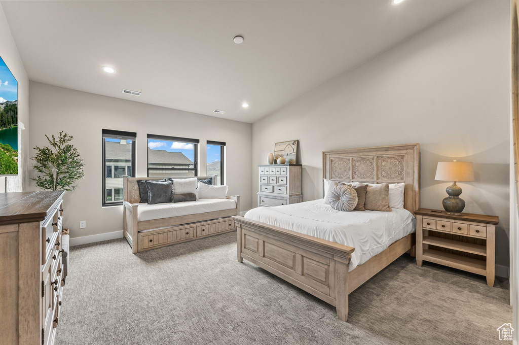 Bedroom featuring light carpet and lofted ceiling