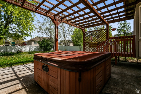 View of terrace with a hot tub and a pergola