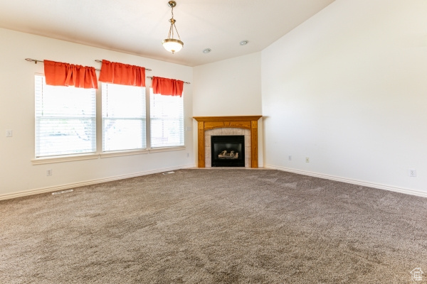 Unfurnished living room with carpet flooring and a fireplace