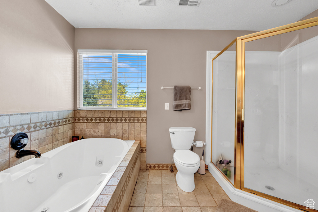 Bathroom featuring tile flooring, independent shower and bath, and toilet