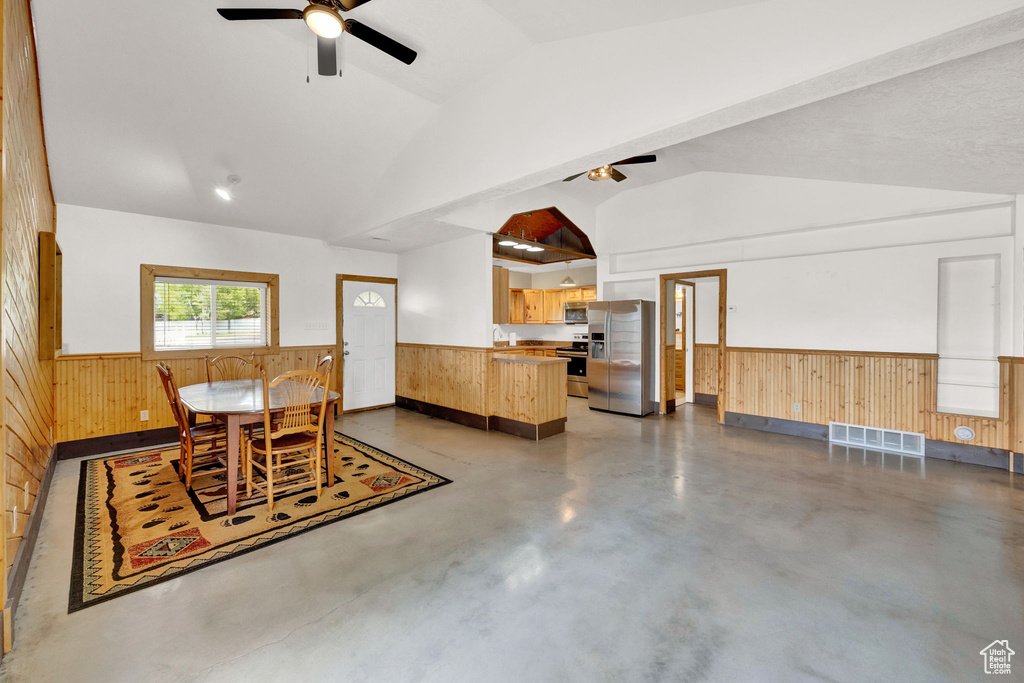 Dining space featuring concrete flooring, ceiling fan, and lofted ceiling