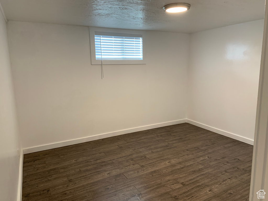 Spare room featuring dark hardwood / wood-style floors and a textured ceiling