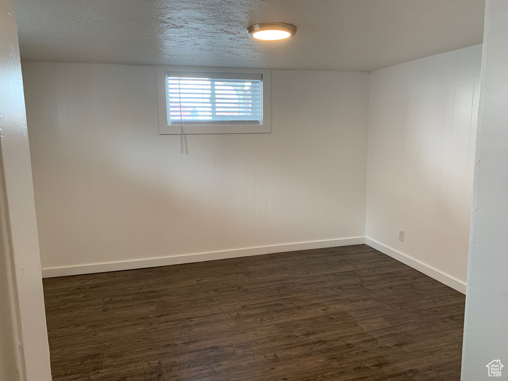 Unfurnished room featuring dark hardwood / wood-style flooring and a textured ceiling