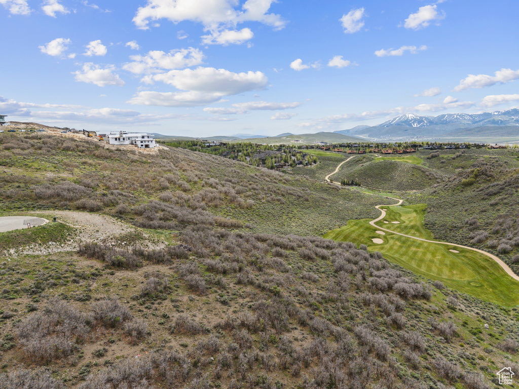 Drone / aerial view of a mountain backdrop and a golf course