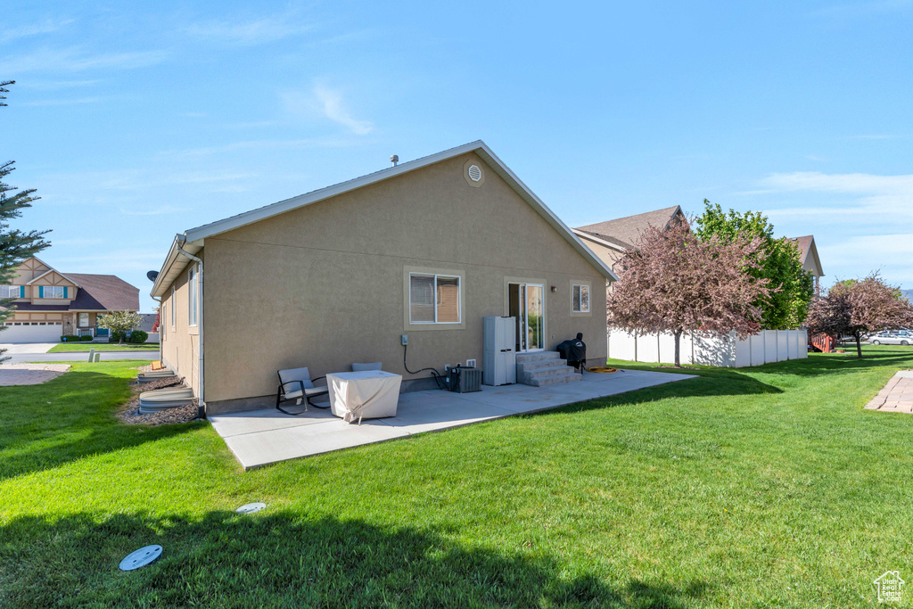 Back of property with a patio and a yard