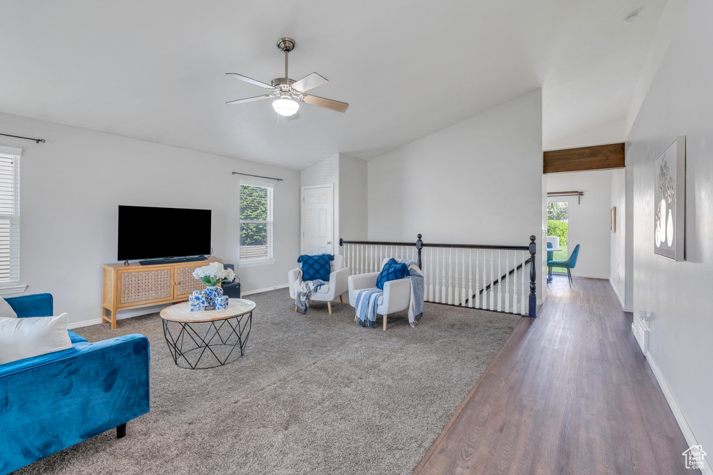 Living room featuring a wealth of natural light, hardwood / wood-style flooring, ceiling fan, and lofted ceiling