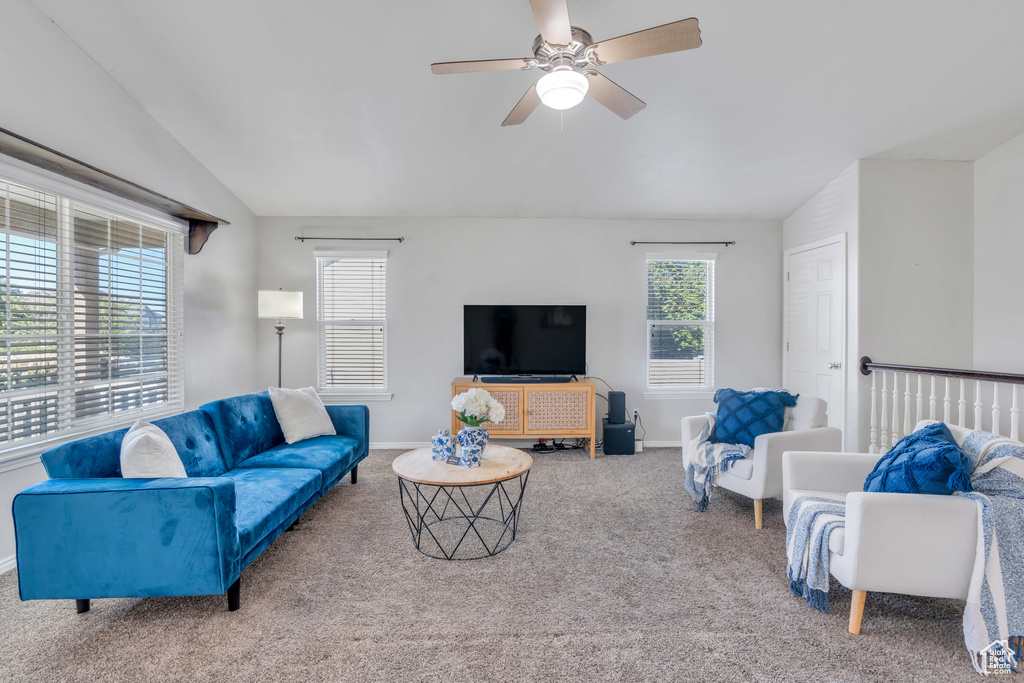 Carpeted living room with lofted ceiling and ceiling fan