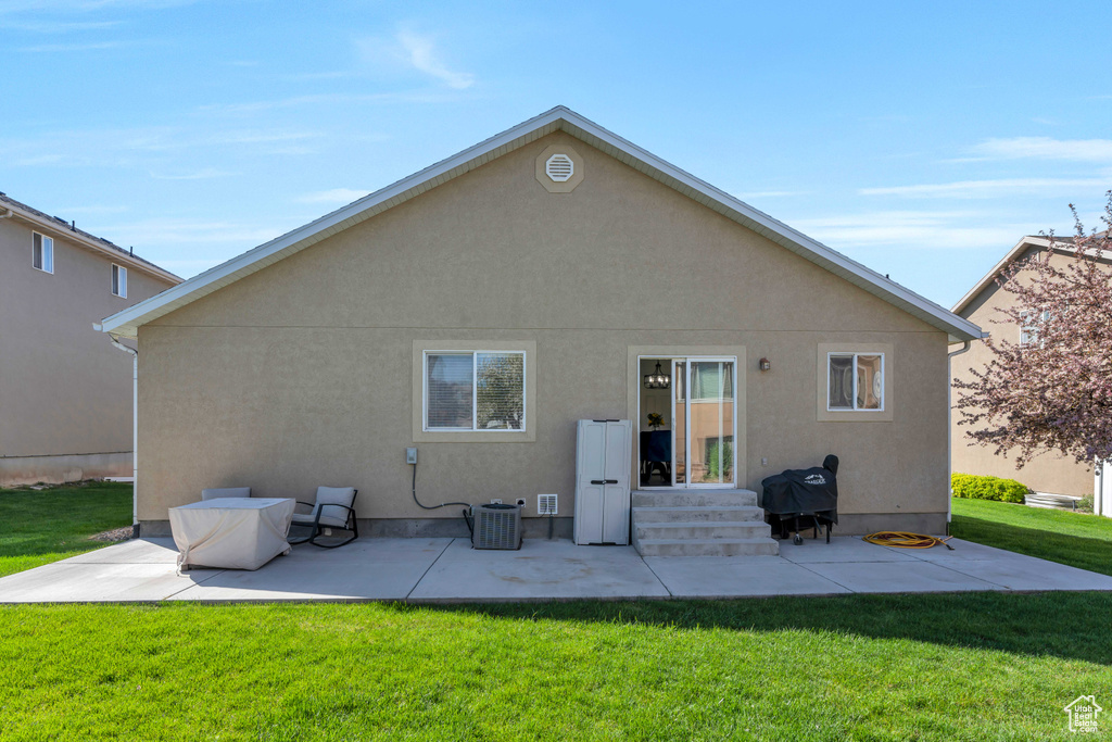 Rear view of house featuring a patio area and a yard