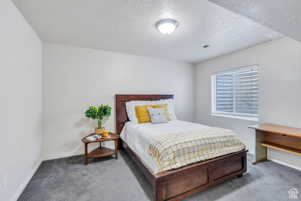 Bedroom featuring a textured ceiling and carpet floors