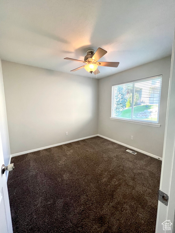 Carpeted empty room featuring ceiling fan