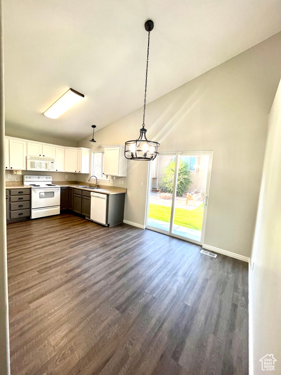 Kitchen with white appliances, vaulted ceiling, pendant lighting, and white cabinets