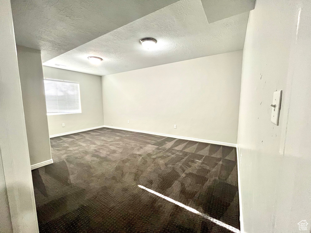 Carpeted empty room featuring a textured ceiling