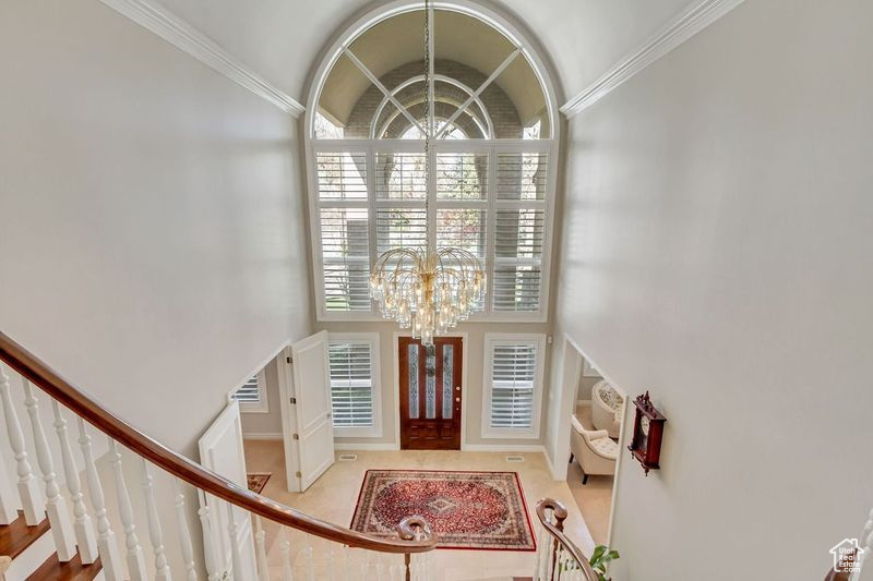 Entrance foyer with ornamental molding and an inviting chandelier