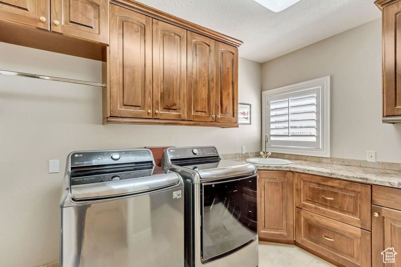 Laundry area featuring washer and clothes dryer and cabinets