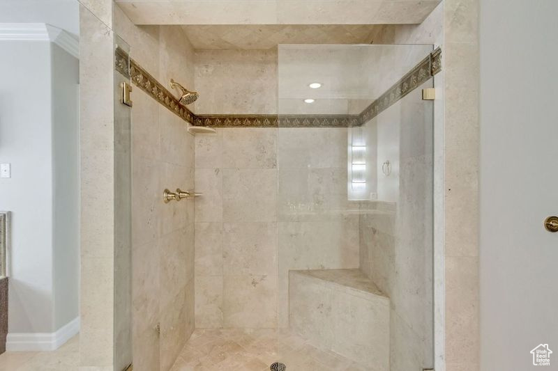 Bathroom featuring crown molding and tiled shower