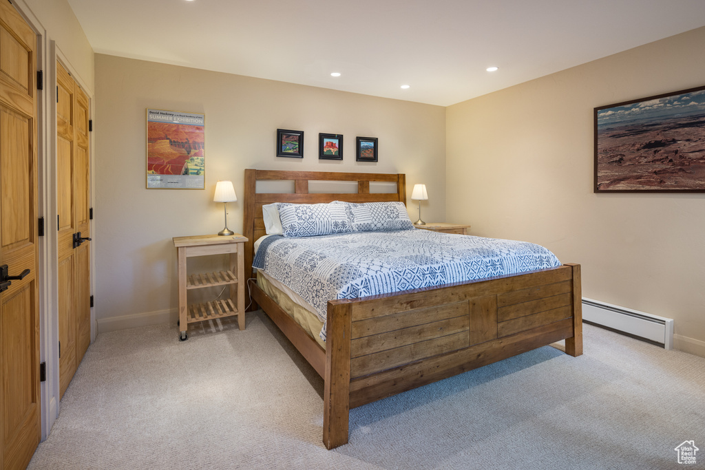 Carpeted bedroom featuring a baseboard heating unit