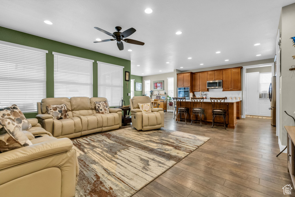 Living room featuring a healthy amount of sunlight, ceiling fan, and hardwood / wood-style flooring