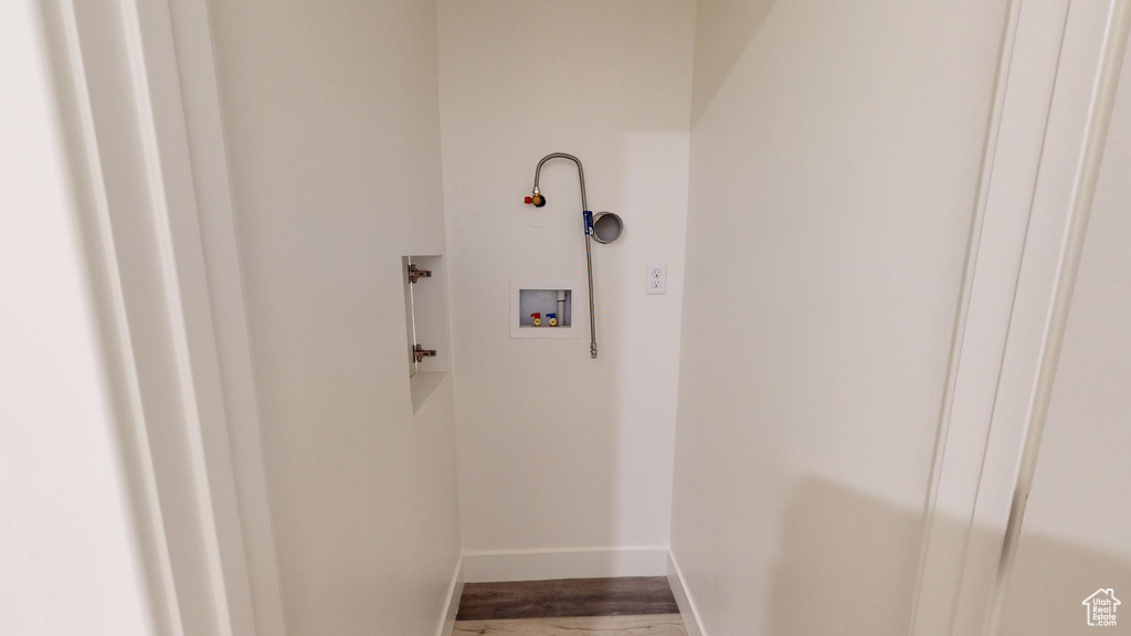 Clothes washing area with hardwood / wood-style flooring and washer hookup