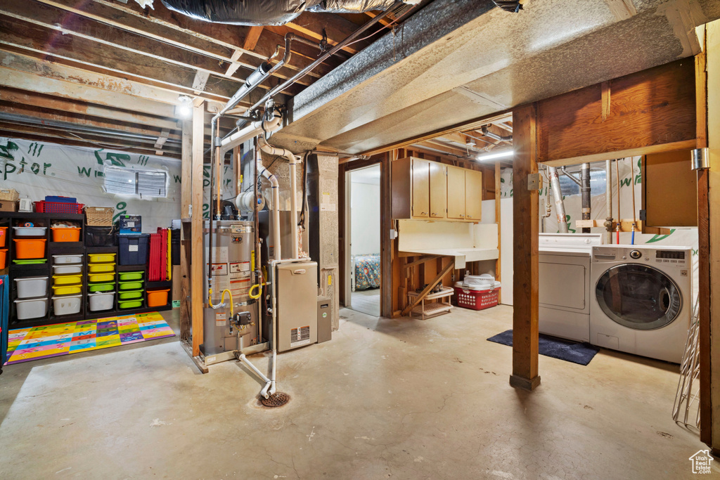 Basement featuring heating utilities, washing machine and clothes dryer, and gas water heater